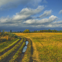 Дорога в осінь: лагідне жовтневе сонечко зблиснуло моцно, та ось-ось із тих хмар посиплеться дощик.