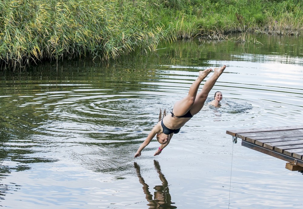 прыжок в речку. прыжок в речку. мужчина у озера. прыгает в воду. прыжок в реку.