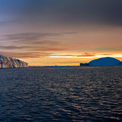 Гренландия.   Айсберги на закате дня